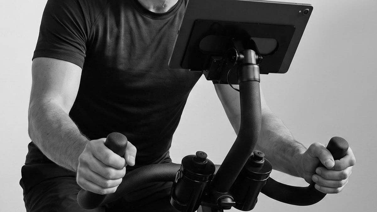 A rider's torso, arms and hands on the CAROL Bike handlebars, black and white